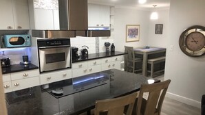 Una cucina moderna con isola centrale, forno a incasso, microonde ed elettrodomestici in acciaio inossidabile.