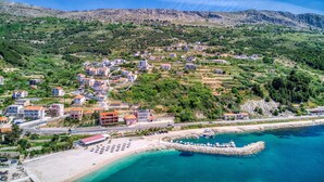 An aerial view of a coastal town with buildings, a beach, and a rocky shoreline. - Seaview Villa MaToLi with heated 50sqm pool and 4 bedrooms, close to Split (Podstrana)
