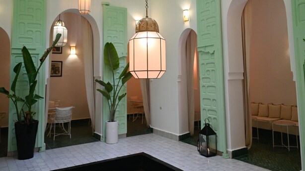 A spacious indoor area with a pool, green-painted walls, and multiple doorways leading to different rooms. - Riad Dar Rabiaa (Rabat)