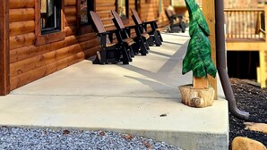 Un chalet en bois doté d’un porche couvert, portant le numéro 2685, et d’un espace extérieur aménagé pour s’asseoir.
