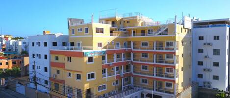 A multi-story hotel with balconies, air conditioning units, and a sign for 'Aparthotel'.