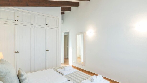 A bedroom with two beds, a wardrobe, a mirror, and a wooden ceiling beam. - 3 Bedroom Villa, Private Pool, Close to the beach, Binibeca (Binibeca)
