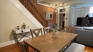 A dining area with a wooden table, chairs, and a ceiling fan. A staircase is visible in the background. - Home Sweet Home @Trolley Square!<br><br>https://goo.gl/maps/f1XX68qiTRCU7eFk7<br> (Wilmington)