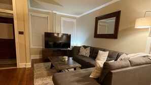 A living room with a gray sectional sofa, a coffee table, and a TV. - Home Sweet Home @Trolley Square!<br><br>https://goo.gl/maps/f1XX68qiTRCU7eFk7<br> (Wilmington)