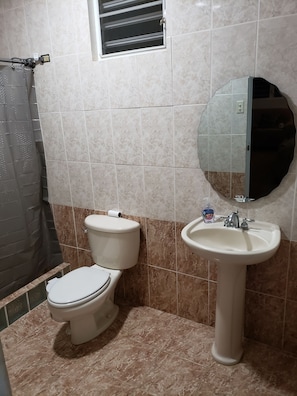 A bathroom with a toilet, sink, and mirror. - Cozy farmhouse w/ private pool near beaches & tourist attractions (Palmarejo ward)