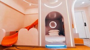 A modern room with a bed, a circular light fixture, and a white door. - Tonghe Hotel (Shimian)