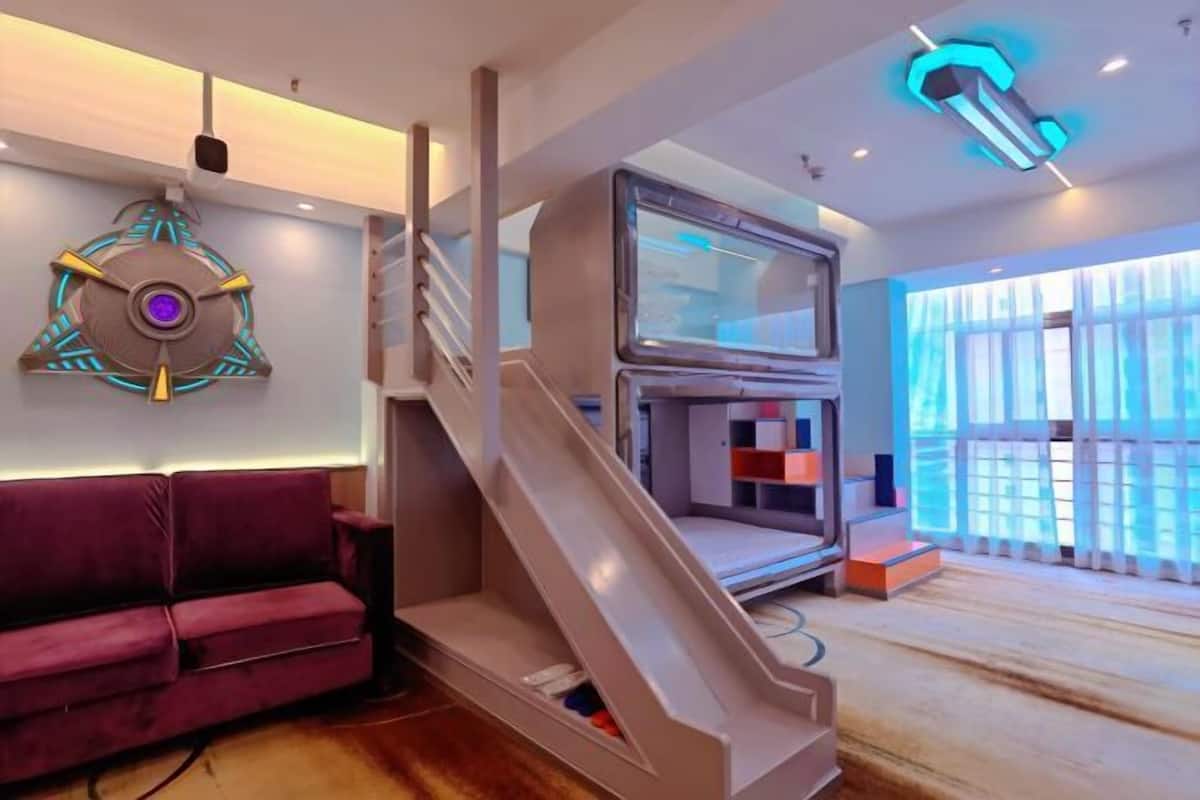 A modern interior with a staircase, a sofa, and a television.