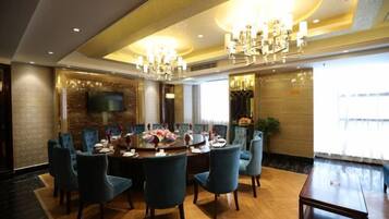 A dining area with a round table, multiple chairs, and a chandelier.