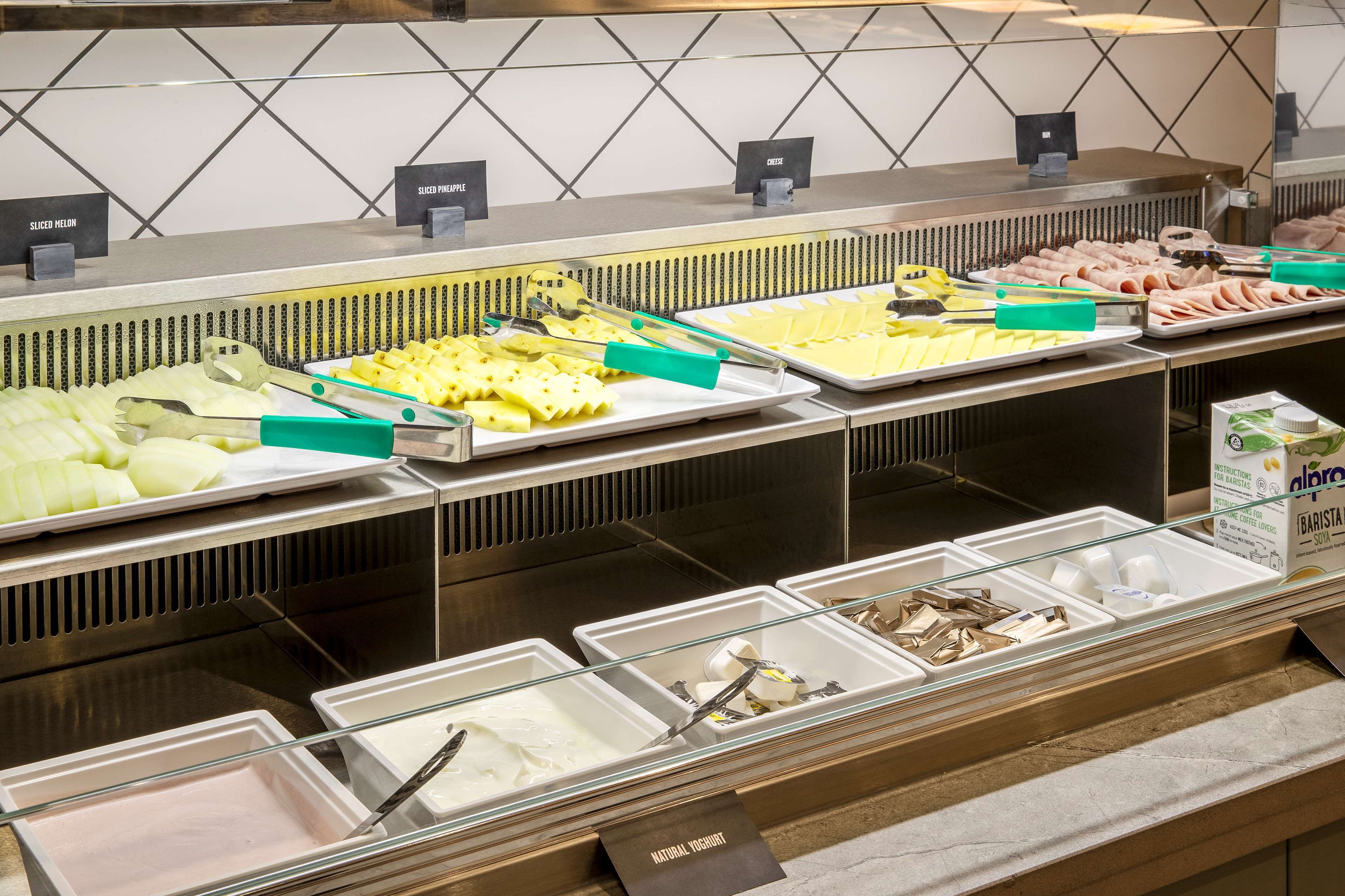 A buffet with various food items and utensils.