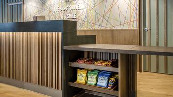 A reception desk with a modern design, featuring a wooden panel and a colorful geometric wall art.