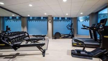 A gym with treadmills, a rowing machine, and a bench press.