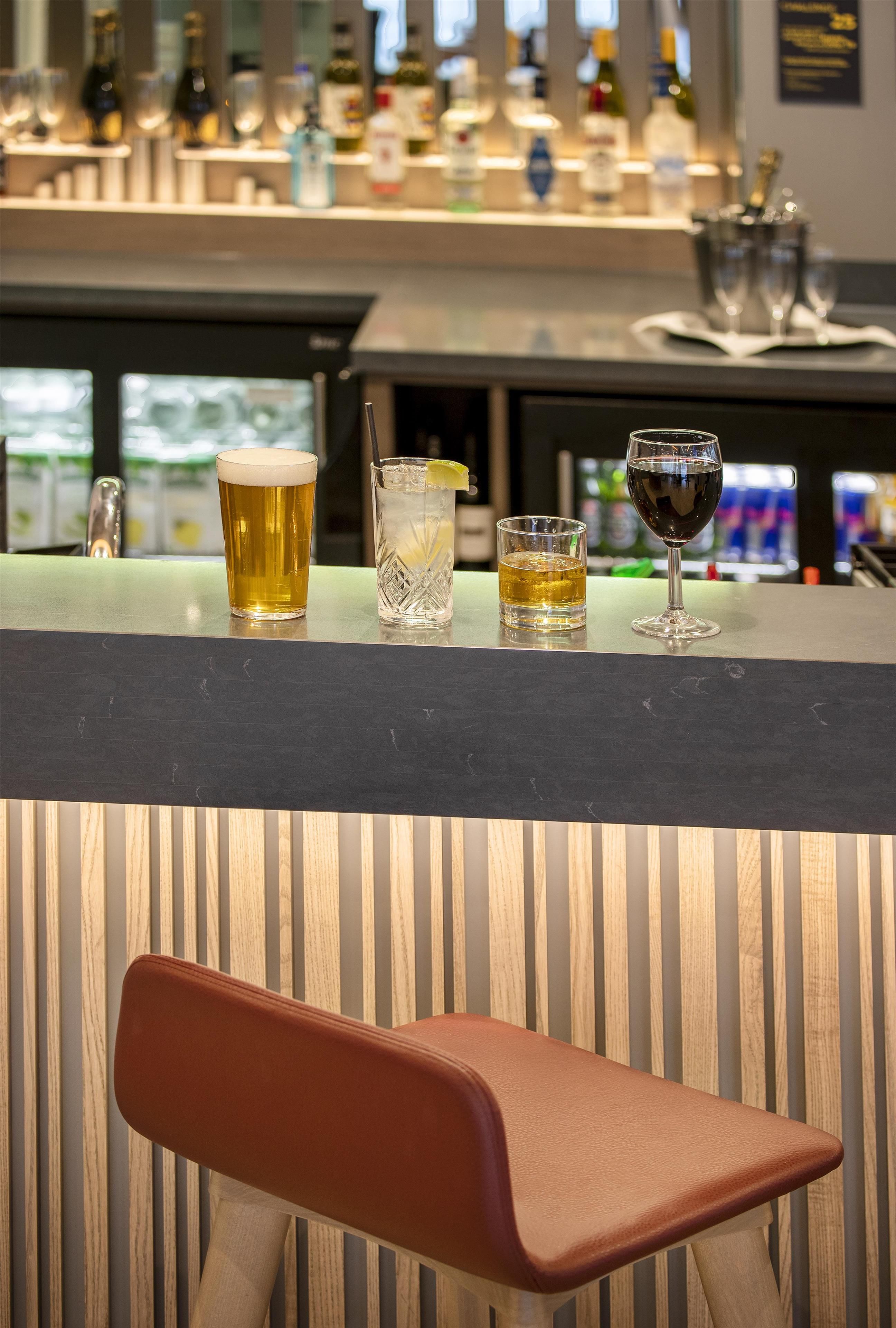 A bar area with a variety of drinks and bottles in the background.