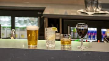 A bar area with a variety of drinks and bottles in the background.