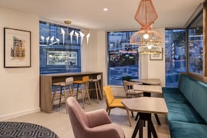 Un interior moderno con zona de bar, asientos y ventanas amplias con vistas a la ciudad.