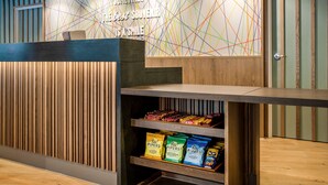 Una recepción con un llamativo diseño mural geométrico y un panel de madera de fondo.