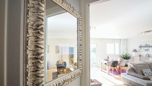 A spacious living room with a large mirror, a dining area with a table and chairs, and a cozy seating area with a sofa. - -DALIA- APPARTEMENT CENTRE-VILLE-TERRASSE-PARKING (Concarneau)
