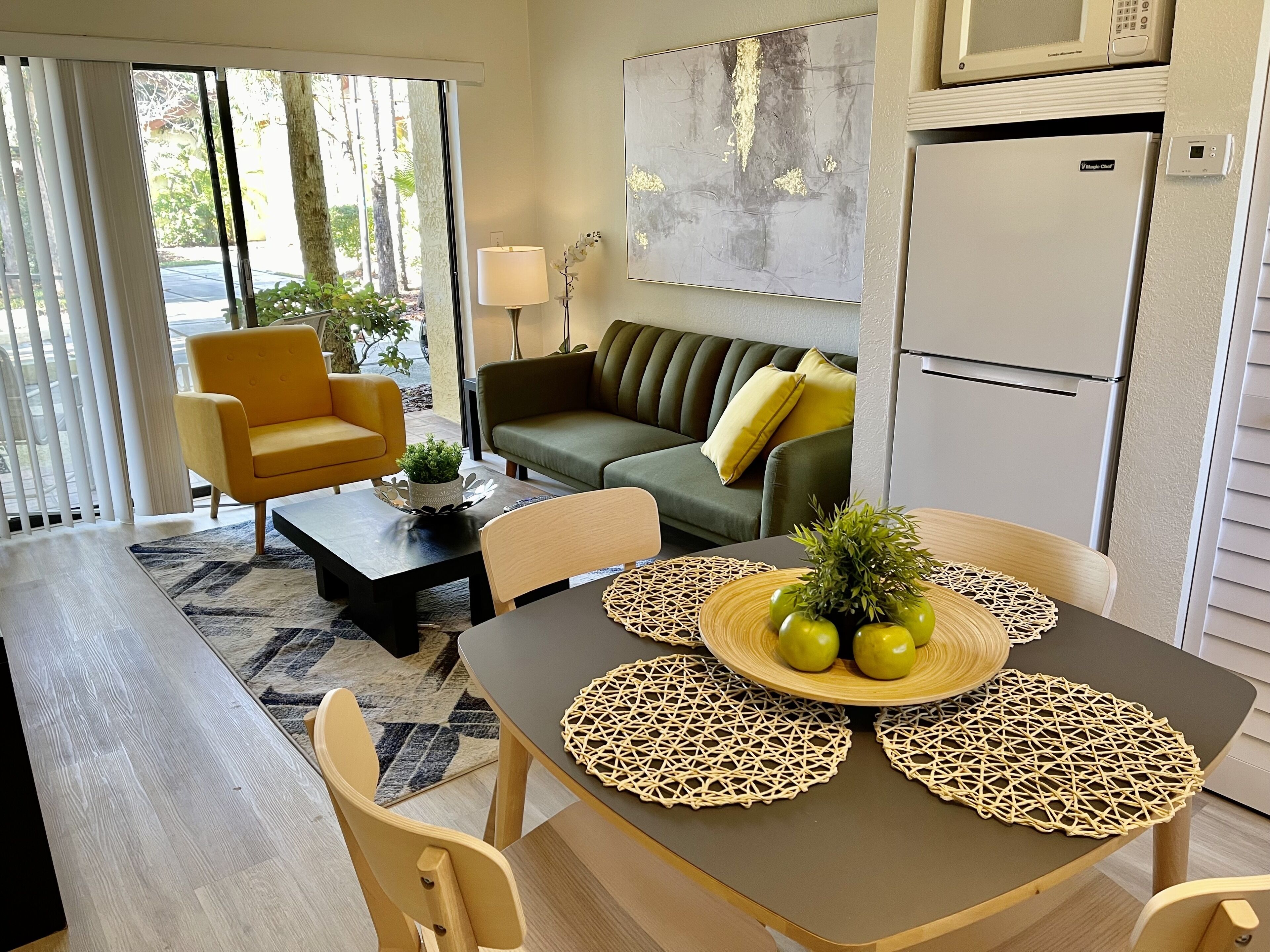 Una sala de estar moderna con una mesa de comedor, sillas, un sofá y una mesa de centro.