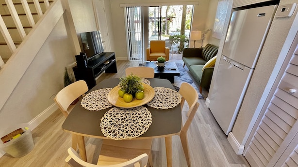 A compact living space with a dining table, chairs, a sofa, a TV, and a refrigerator. - LOCATION! LOCATION! LOCATION!  Best location in Orlando (Orlando)