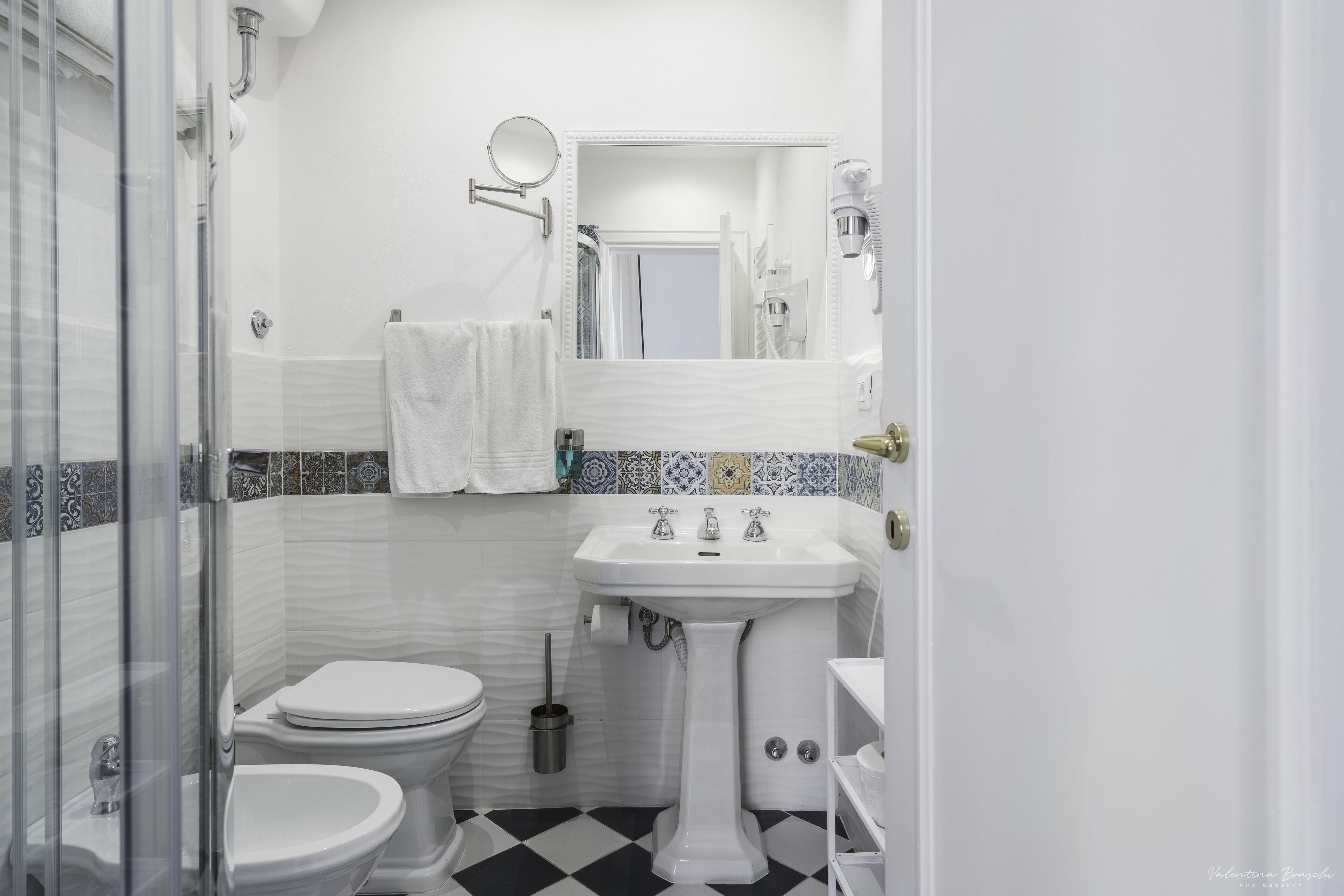 A bathroom with a white sink, a toilet, and a shower area.