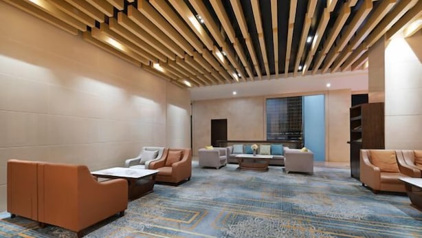 A modern lounge area with sofas, a coffee table, and a patterned carpet. - Dongguan Xiegang FONTOO Hotel (Dongguan)