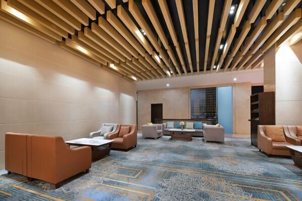 A modern lounge area with sofas, a coffee table, and a patterned carpet. - Dongguan Xiegang FONTOO Hotel (Dongguan)