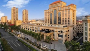 A hotel with a classical architectural style, featuring a prominent entrance with a canopy and a large arched window. - Dongguan Xiegang FONTOO Hotel (Dongguan)