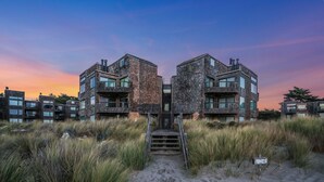 A modern building with a symmetrical design, featuring a central staircase leading to the entrance. - Serene & Modern~ Ocean Front View~ 2 Bd 2 Bth~1st Fully Remodeled (Watsonville)