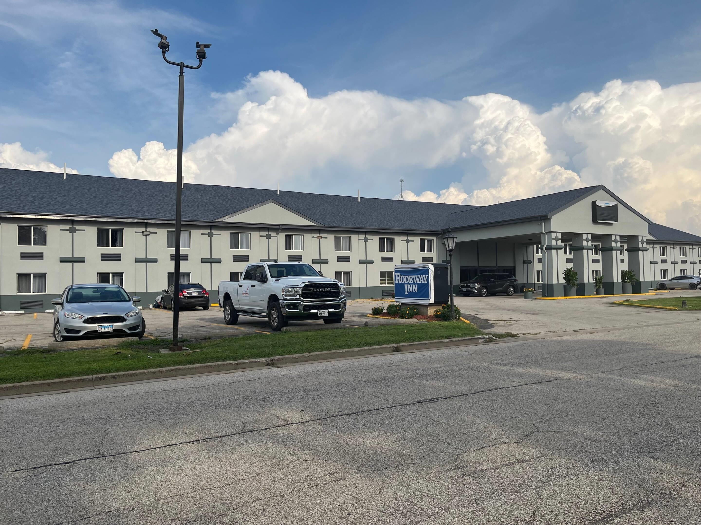 Ein Hotel mit Parkplatz, Auffahrt und einem Schild für Rodeway Inn.