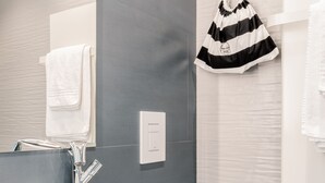 A modern bathroom with a white sink, a toilet, and a towel rack. - Anjoy & Bleev Rooms | SARDINA | Queen French bed room (Rho)