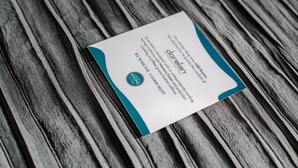 A business card on a wooden surface. - Anjoy & Bleev Rooms | SARDINA | Queen French bed room (Rho)