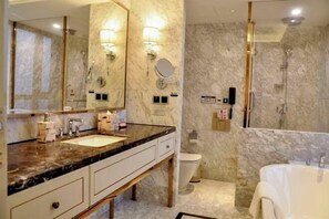 A modern bathroom with a marble vanity, dual sinks, a large mirror, a toilet, and a separate shower area. - Jincheng International Hotel (Jinhua)