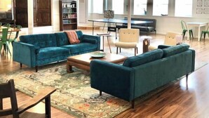 A spacious living area with a blue sofa set, a coffee table, and a patterned rug. - 4Bd 2Ba Converted Historic Church in Uptown Butte! (Butte)