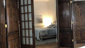 A bedroom with a bed, a nightstand, and a wall-mounted lamp. - 4Bd 2Ba Converted Historic Church in Uptown Butte! (Butte)