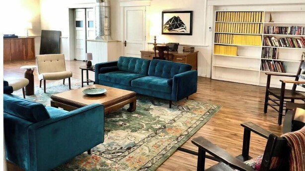 A spacious living room with a blue sofa, a coffee table, and a patterned rug. - 4Bd 2Ba Converted Historic Church in Uptown Butte! (Butte)