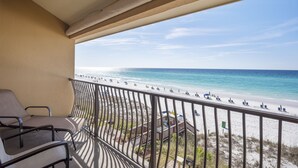 Un balcon avec vue sur une plage et l’océan.