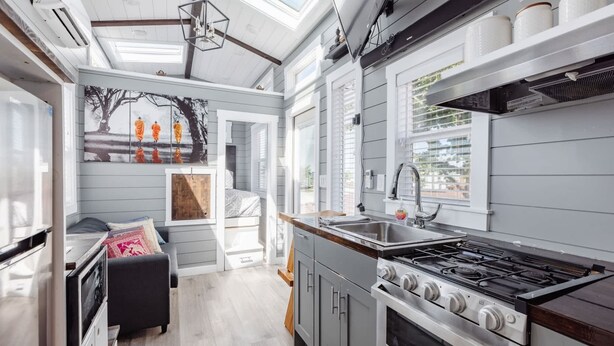 A compact kitchen with a gas stove, a sink, and a window overlooking a garden. - Zion Tiny Home • Pet Friendly • Stargazing Deck (Apple Valley)