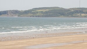 A beach with a sandy shore and gentle waves. - 14 Parc Delfryn (Brynteg)