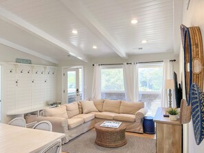 A cozy living room with a beige sectional sofa, a wicker coffee table, and a dining area with a table and chairs. - Dogs, Pool! Single level! Whalehead! Guest Suite! C1084 (Corolla)