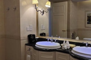 Un baño con dos lavamanos, un espejo grande y una ducha.
