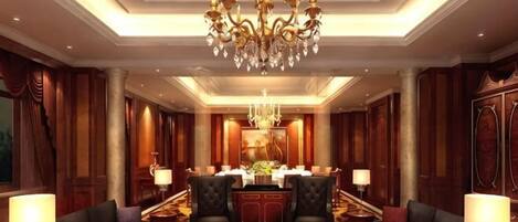 Um lobby luxuoso com um lustre imponente, assentos confortáveis e uma sala de jantar formal.