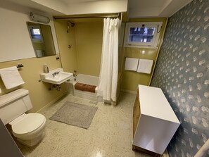 Ein Badezimmer mit Toilette, Waschbecken, Badewanne und Duschvorhang.