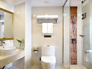 A modern bathroom with a toilet, sink, and shower.