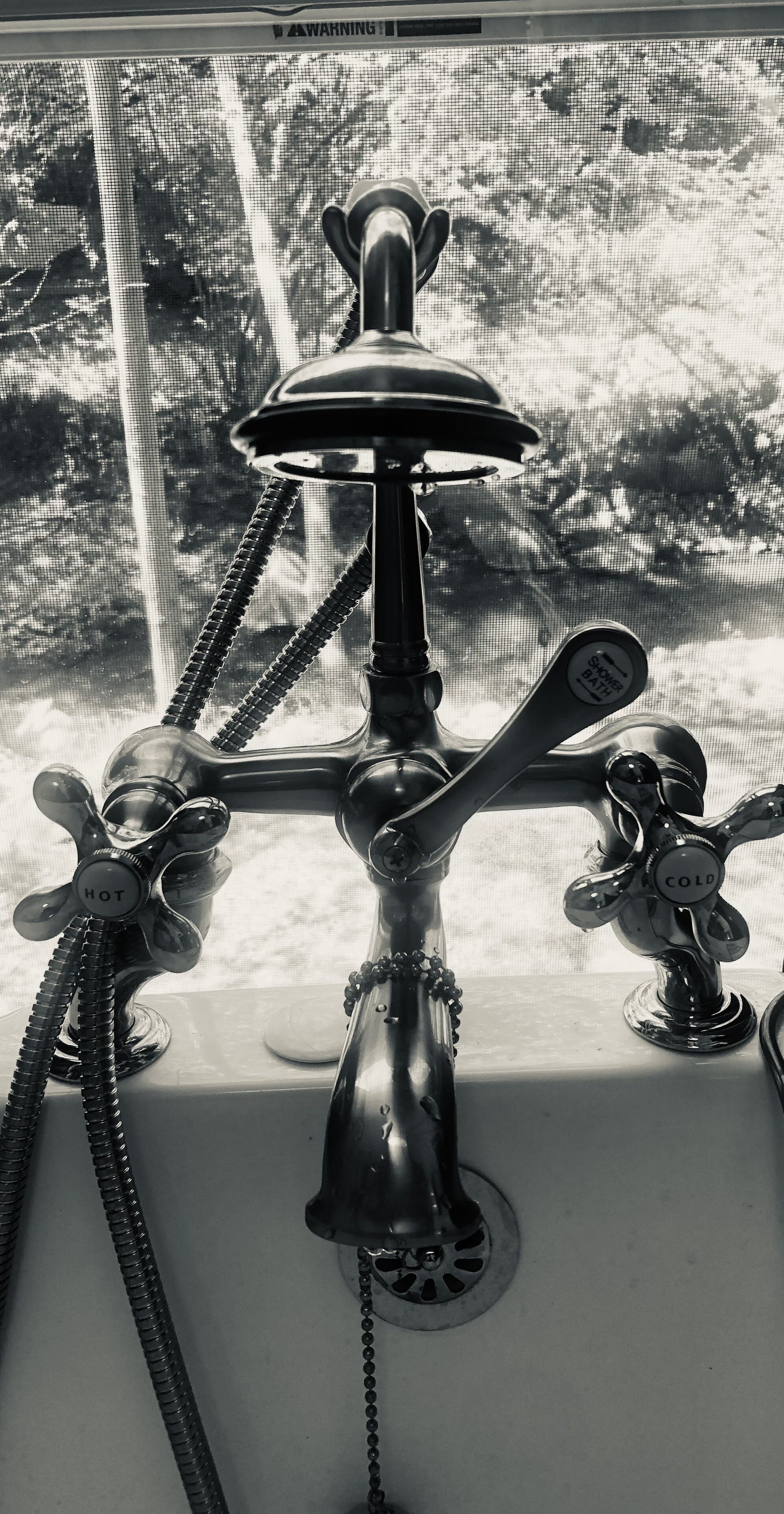 A bathroom with a modern faucet and a showerhead.