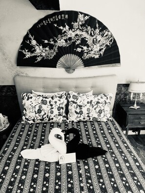 A bed with floral bedding, a fan, and a bedside table with a lamp. - Flume's End (Nevada City)