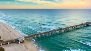 A pier extending into the ocean with a beach on one side. - WPB Elegant 5BR | Hot Tub | Fire Pit | Near Beach (West Palm Beach)