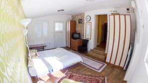 A bedroom with a bed, a dresser, a television, and a wardrobe. - Apartments Old Town Aleksici (Budva)