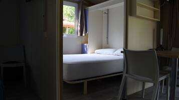 Una habitación pequeña con cama, escritorio y una silla.