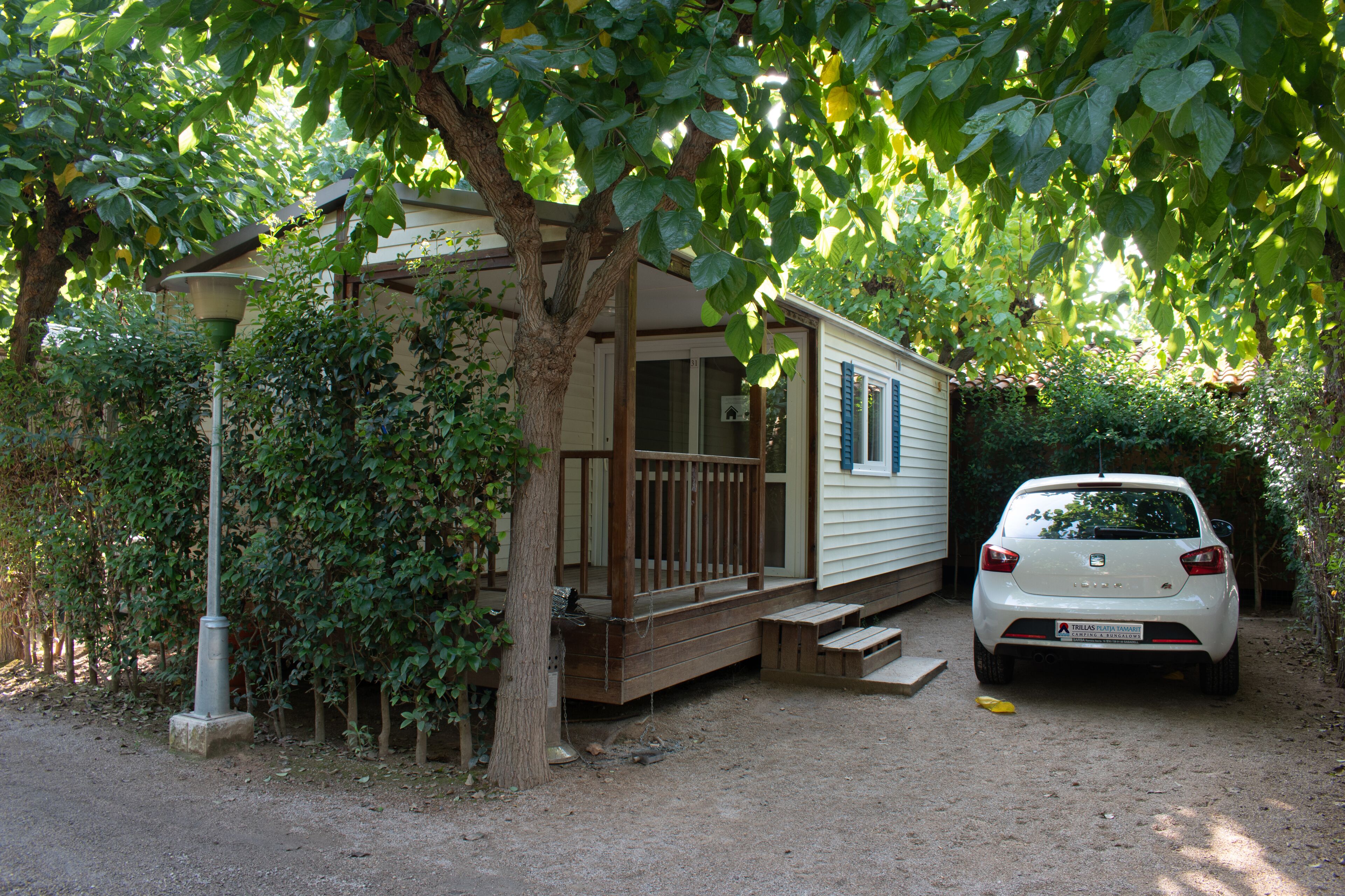 A mobile home with a porch and steps leading to the entrance.