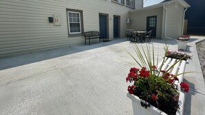 A building with a covered patio area, a bench, and outdoor seating. - All-inclusive Apartment - 1 Bedroom, 1 Bath, Equipped Kitchen, & Laundry (Terre Haute)