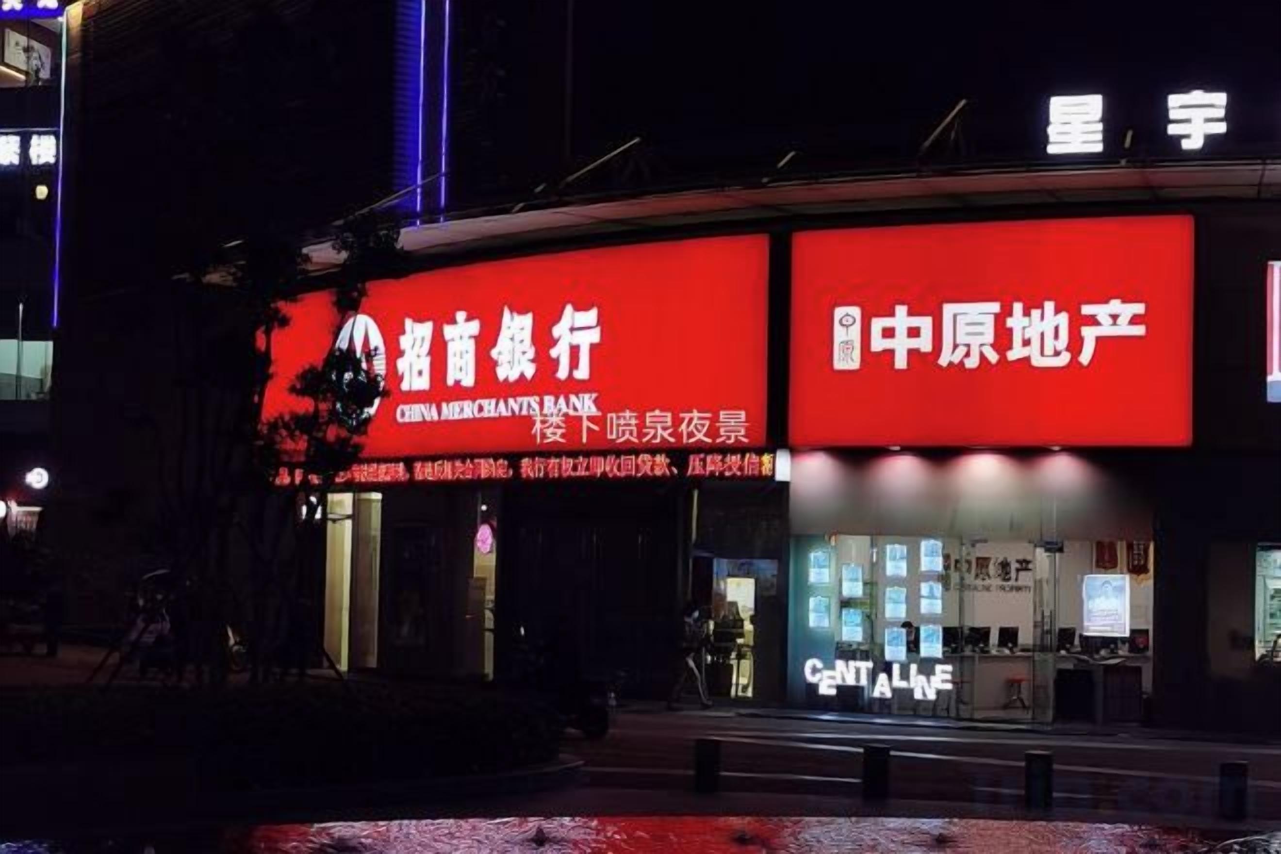 A building with illuminated signage for a bank and a restaurant.